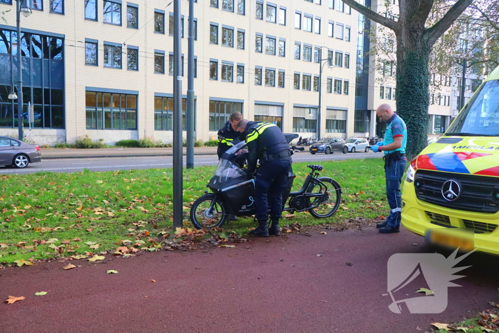 Persoon op bakfiets glijdt onderuit door bladeren op fietspad