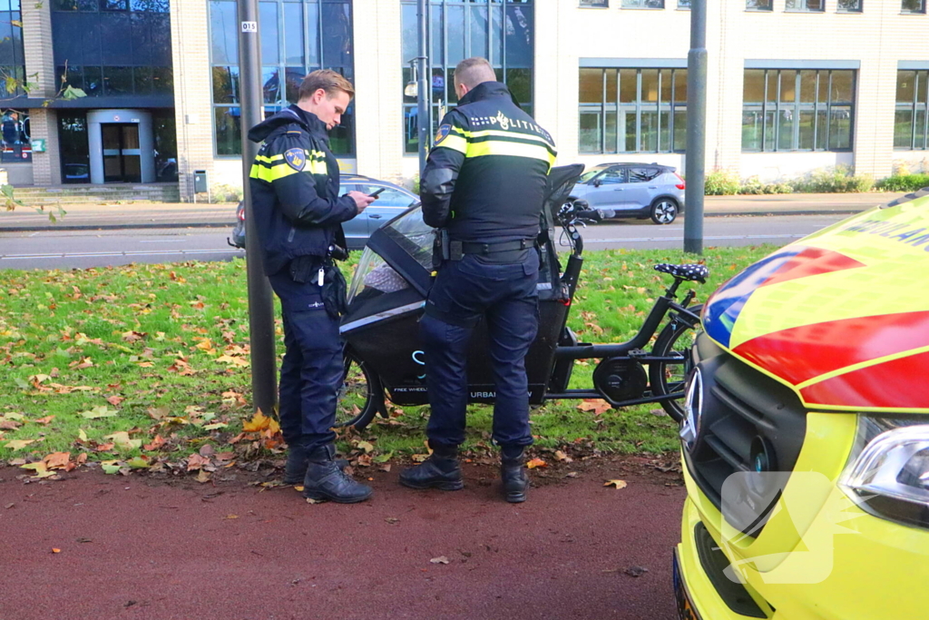 Persoon op bakfiets glijdt onderuit door bladeren op fietspad