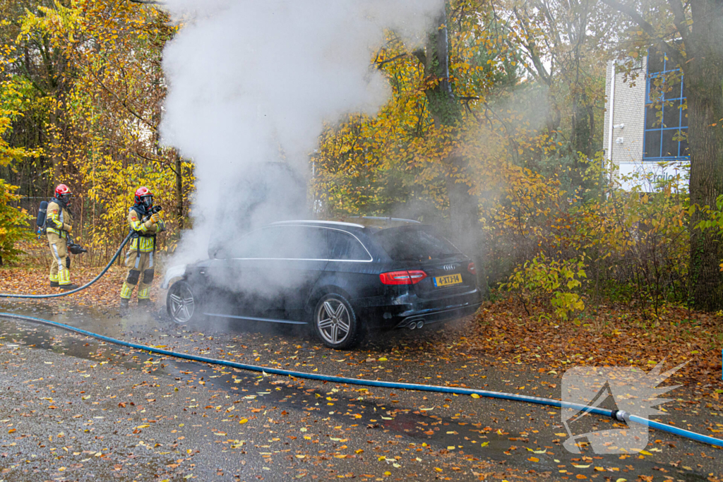 Brandweer blust brand in personenauto