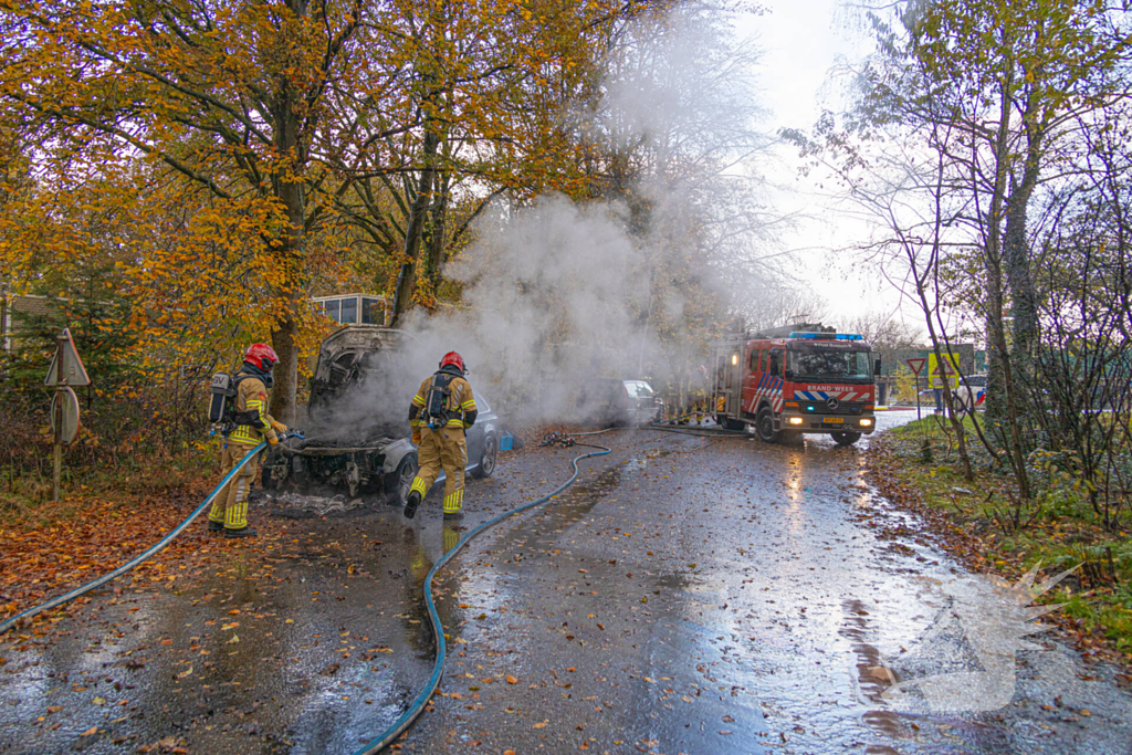 Brandweer blust brand in personenauto