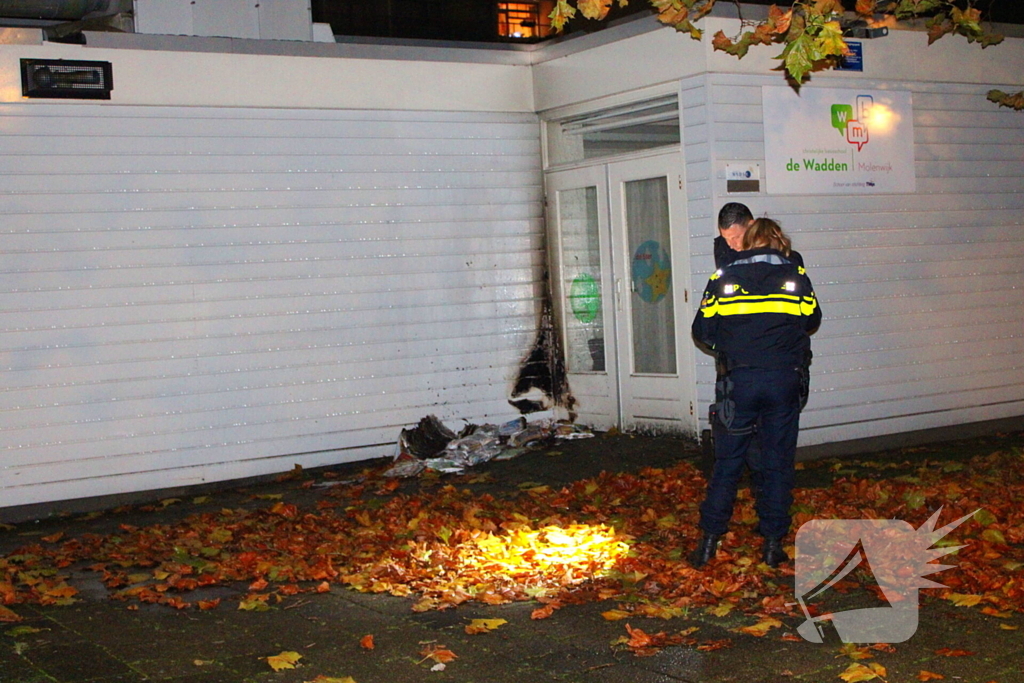 Brand in stapel reclamefolders tegen schoolgebouw