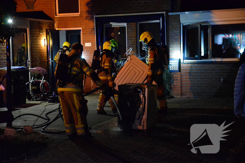 Brandweer blust brandende wasmachine