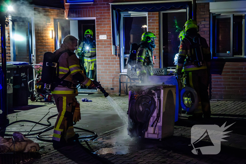 Brandweer blust brandende wasmachine