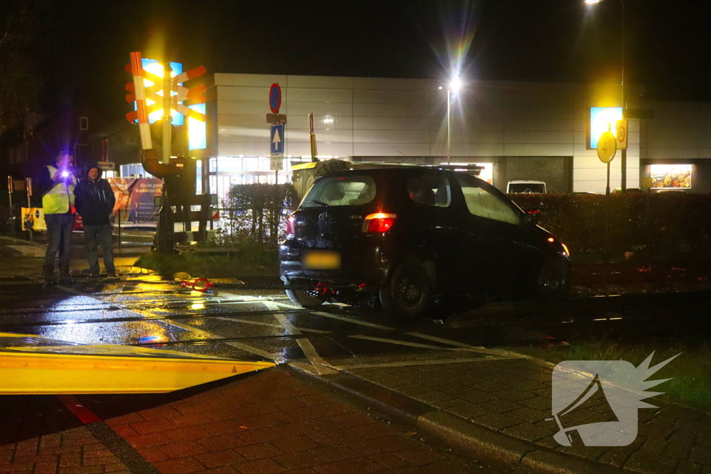 Auto belandt gedeeltelijk op spoor bij overweg