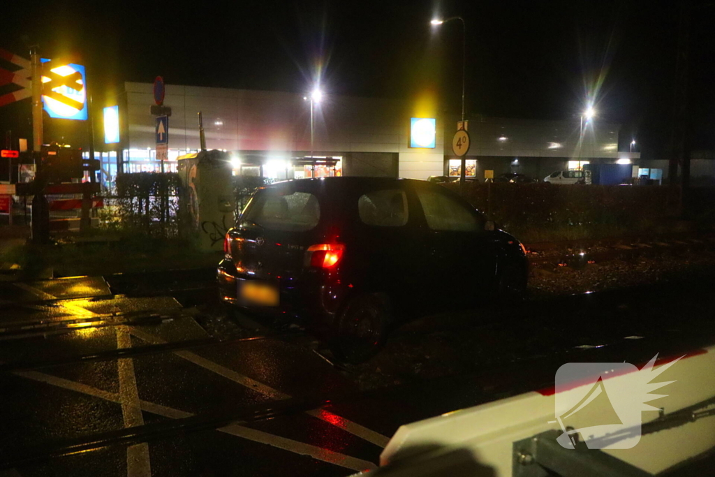 Auto belandt gedeeltelijk op spoor bij overweg