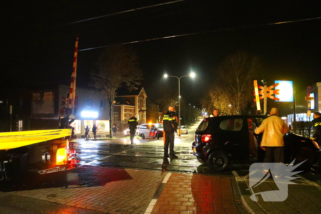 Auto belandt gedeeltelijk op spoor bij overweg