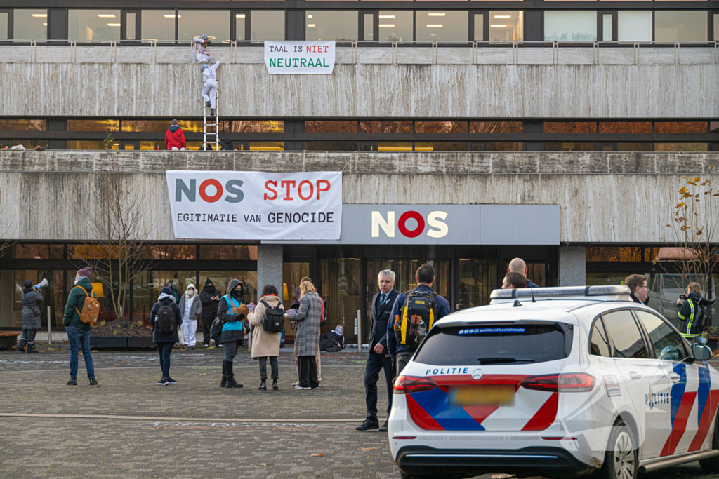 Demonstranten klimmen op het dak van NOS-gebouw