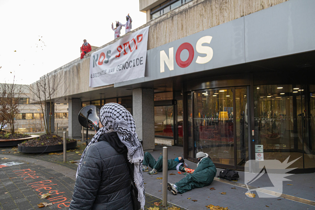 Demonstranten klimmen op het dak van NOS-gebouw