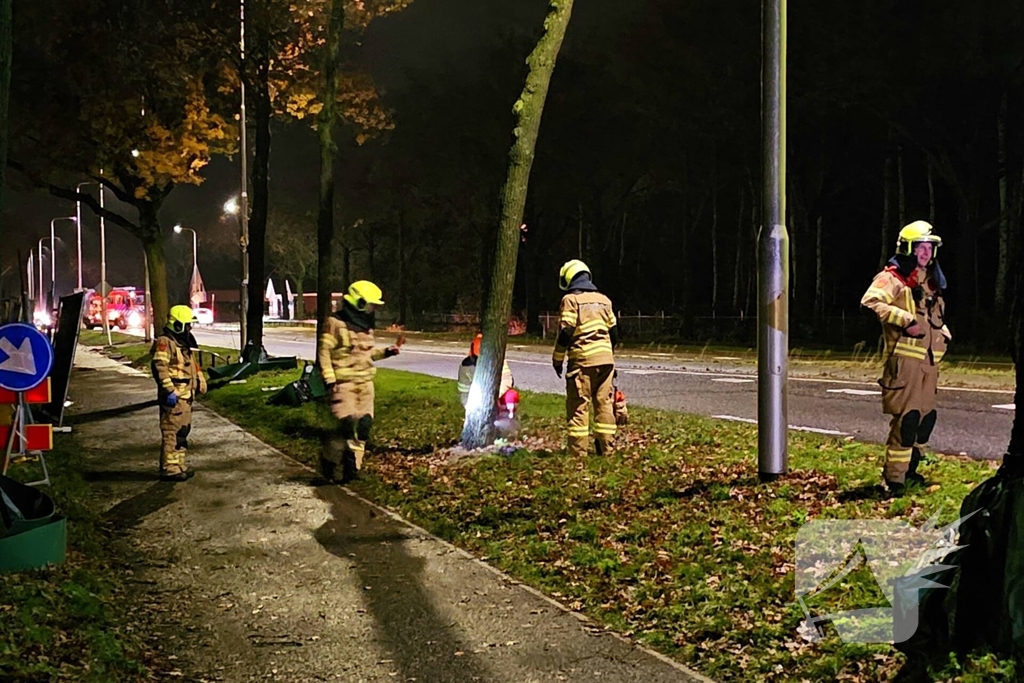 Brandweer zaagt over weg hangende boom om