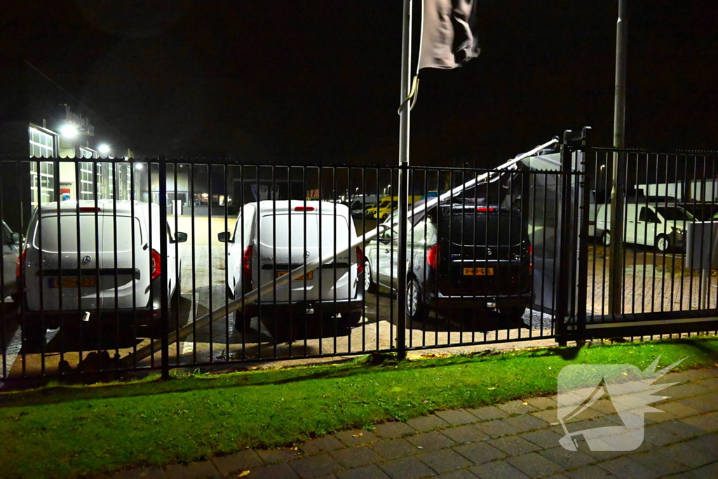 Vlaggenmast belandt op auto door sterke wind