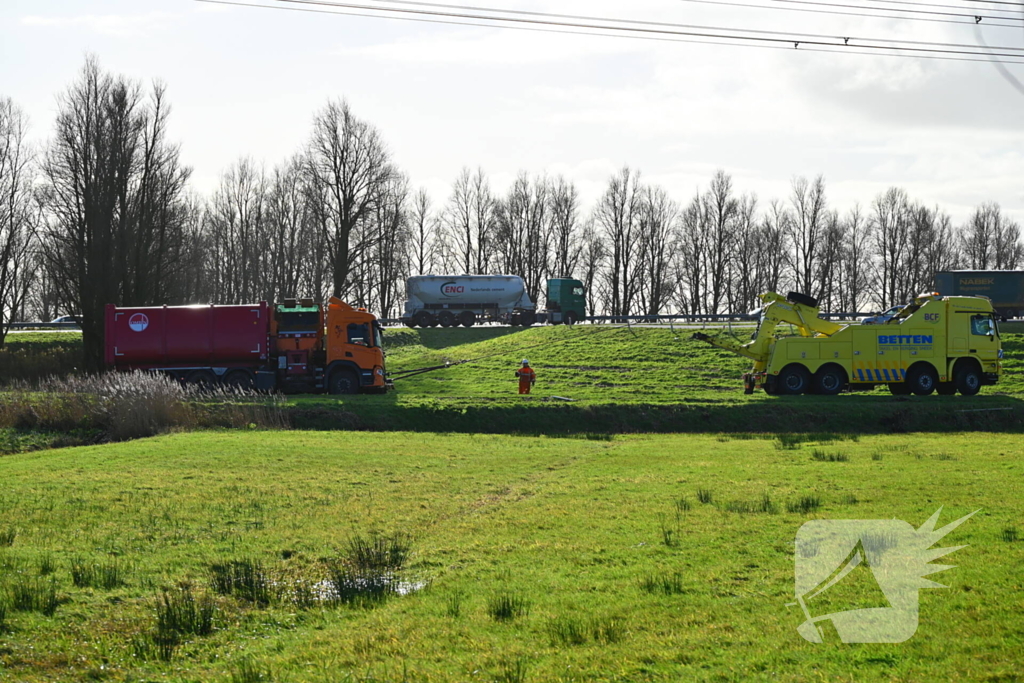 Vrachtwagen komt vast te zitten in weiland