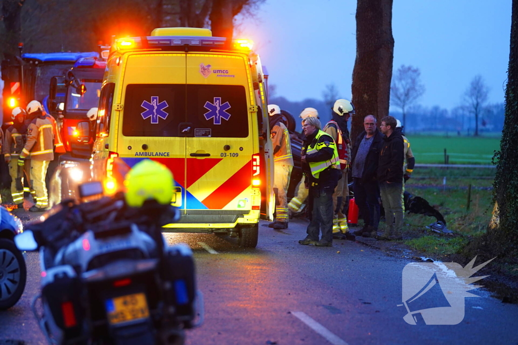 Auto op de kop na botsing met trekker en boom