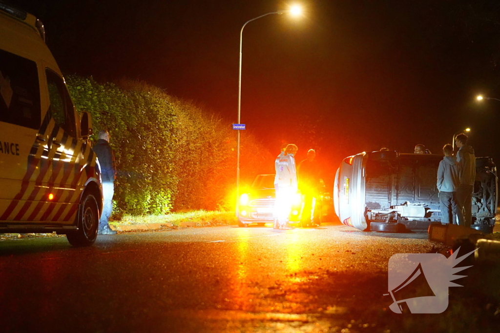 Auto botst tegen lantaarnpaal en belandt op zijkant