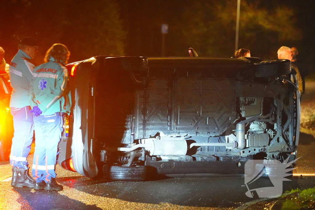 Auto botst tegen lantaarnpaal en belandt op zijkant