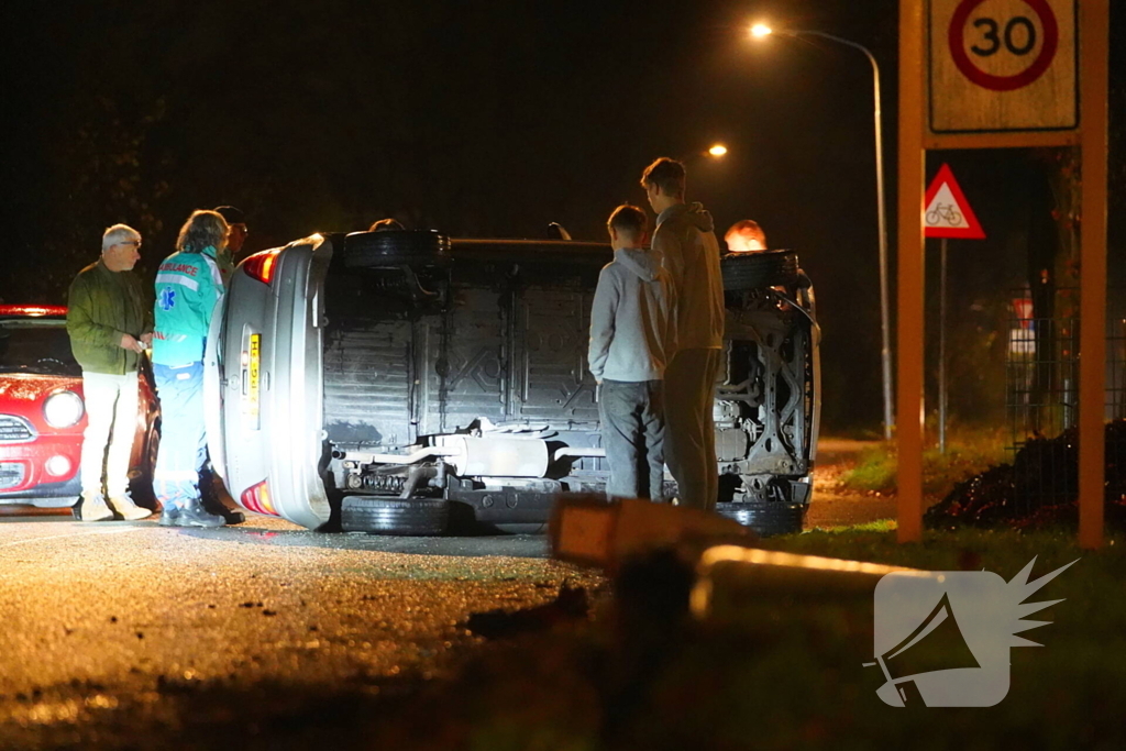 Auto botst tegen lantaarnpaal en belandt op zijkant