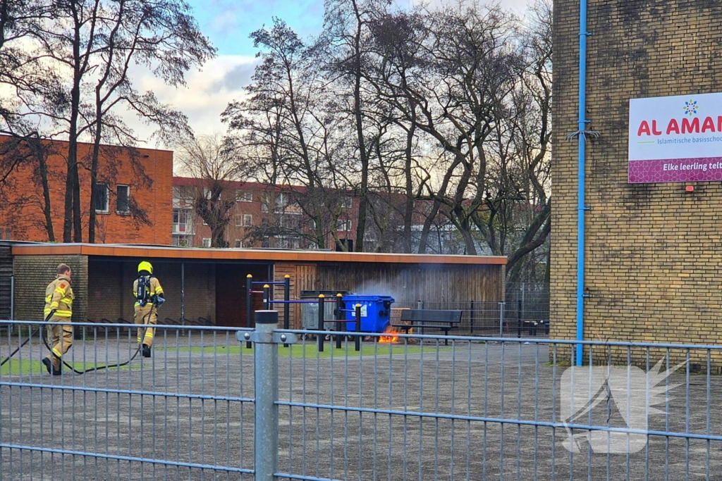 Papiercontainer op schoolplein in brand