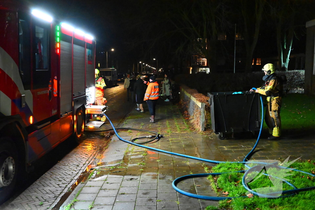 Brandweer blust brand in vuilcontainer