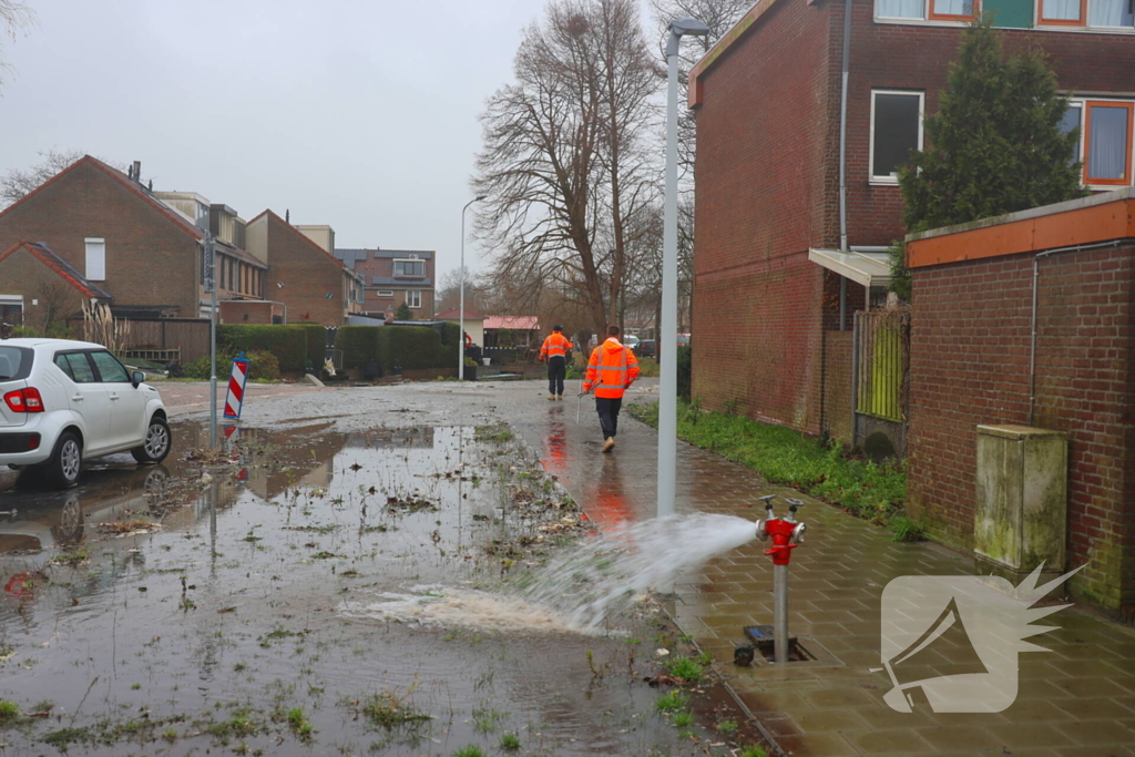 Straat onder water gelopen door kapotte waterleiding