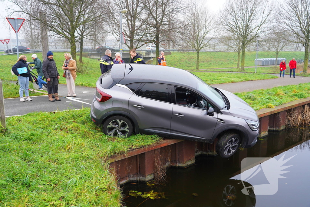 Auto komt boven water te hangen bij keeractie op fietspad