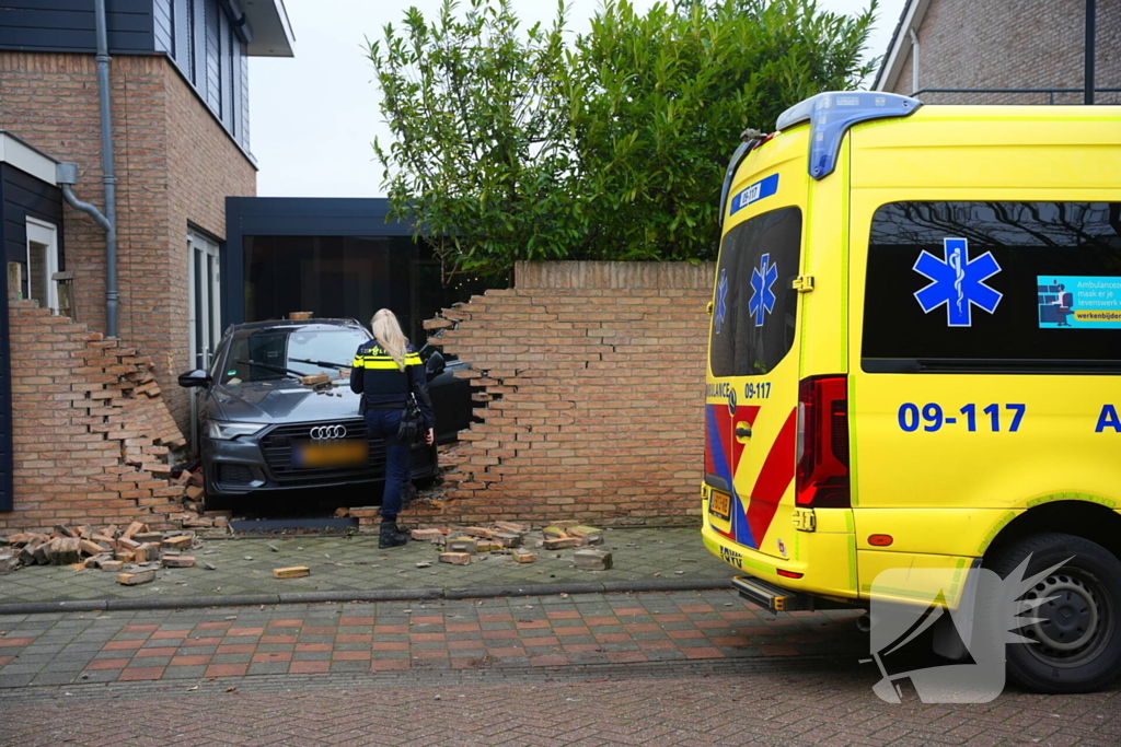 Auto rijdt dwars door tuinmuur