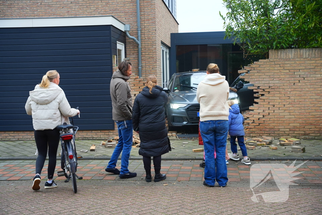 Auto rijdt dwars door tuinmuur