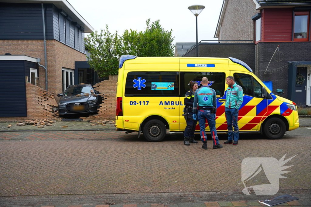 Auto rijdt dwars door tuinmuur