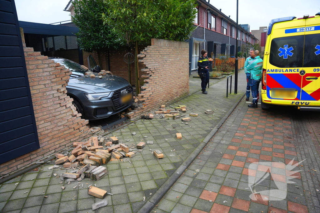 Auto rijdt dwars door tuinmuur