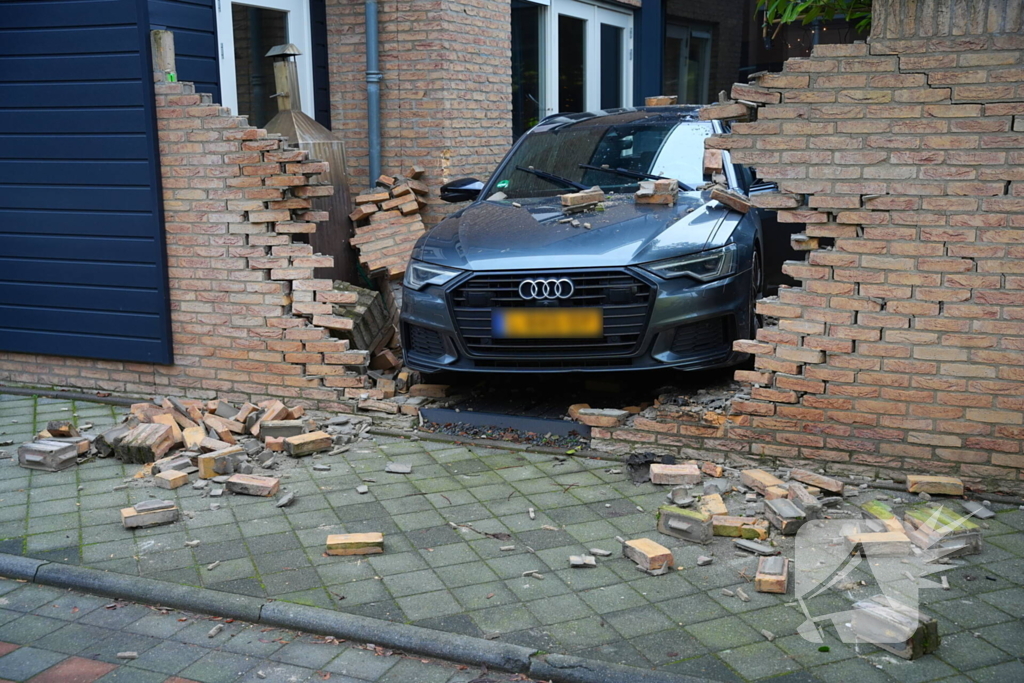 Auto rijdt dwars door tuinmuur