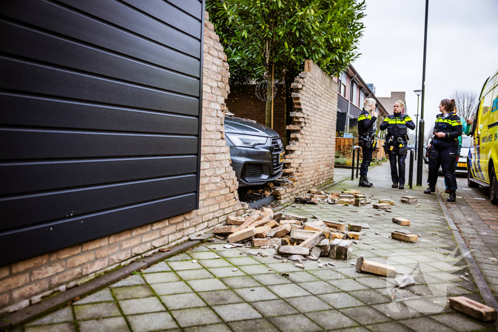 Auto rijdt dwars door tuinmuur