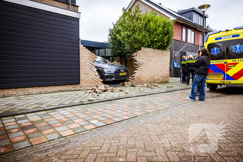 Auto rijdt dwars door tuinmuur