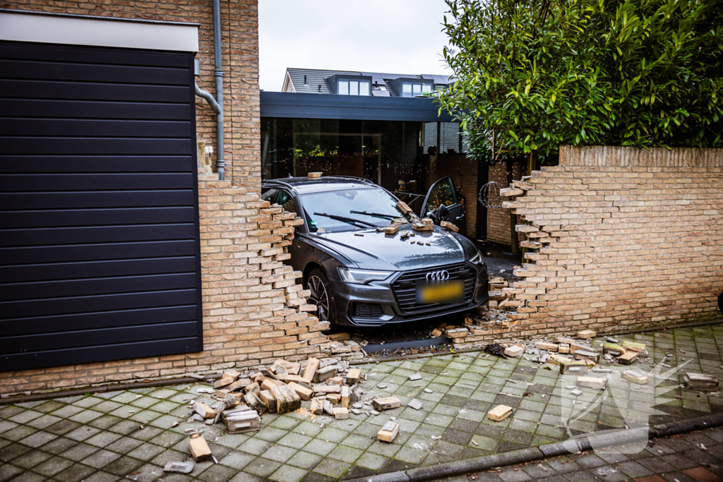 Auto rijdt dwars door tuinmuur