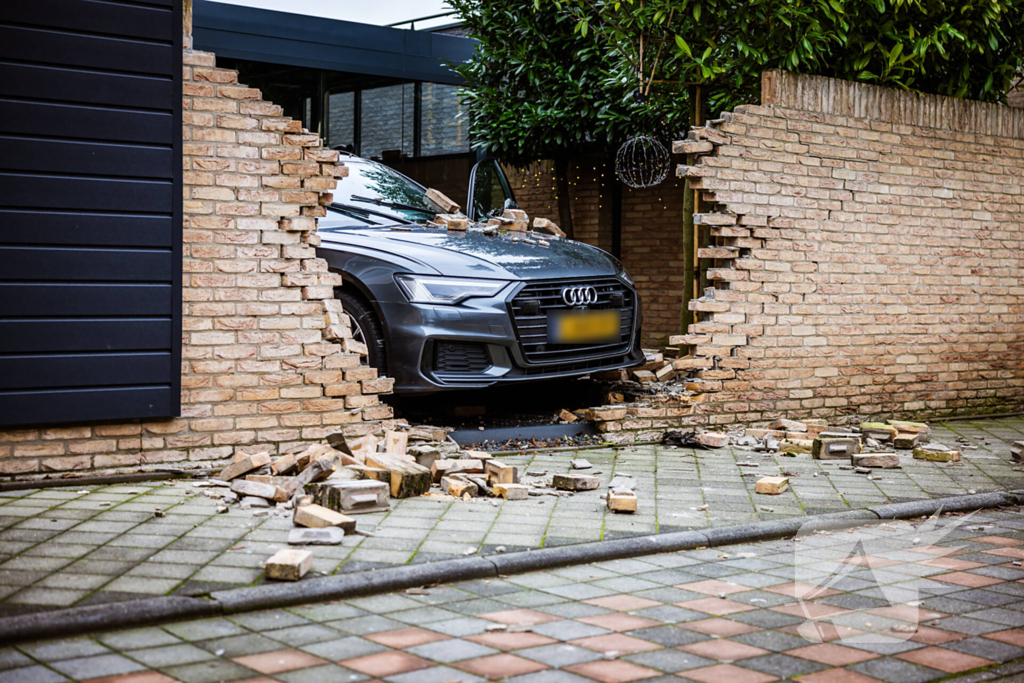 Auto rijdt dwars door tuinmuur