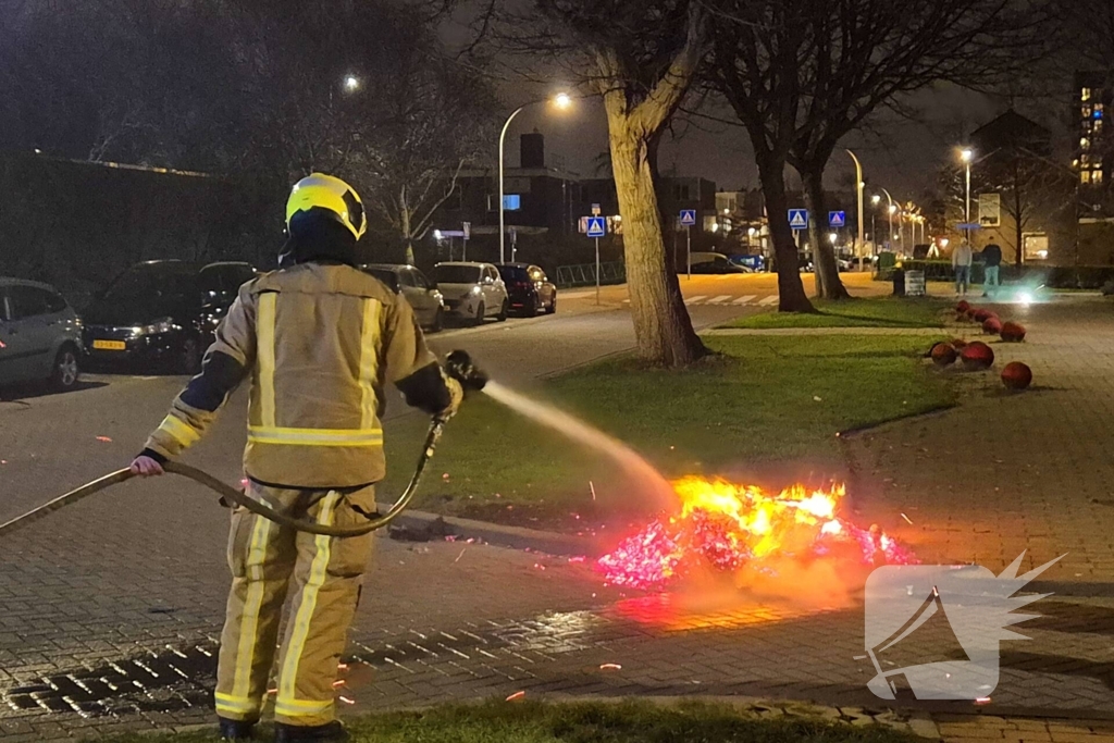 Brandweer blust afvalbrand op straat