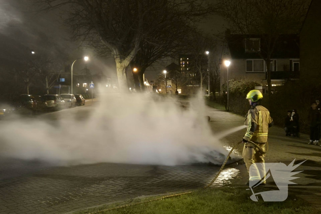 Brandweer blust afvalbrand op straat