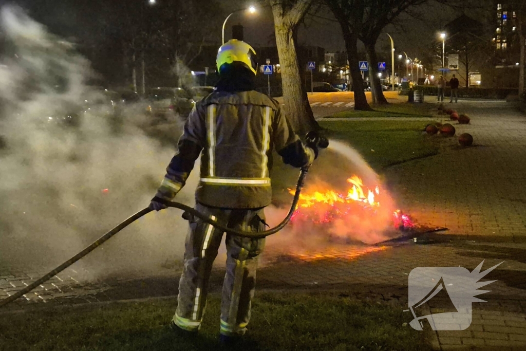 Brandweer blust afvalbrand op straat