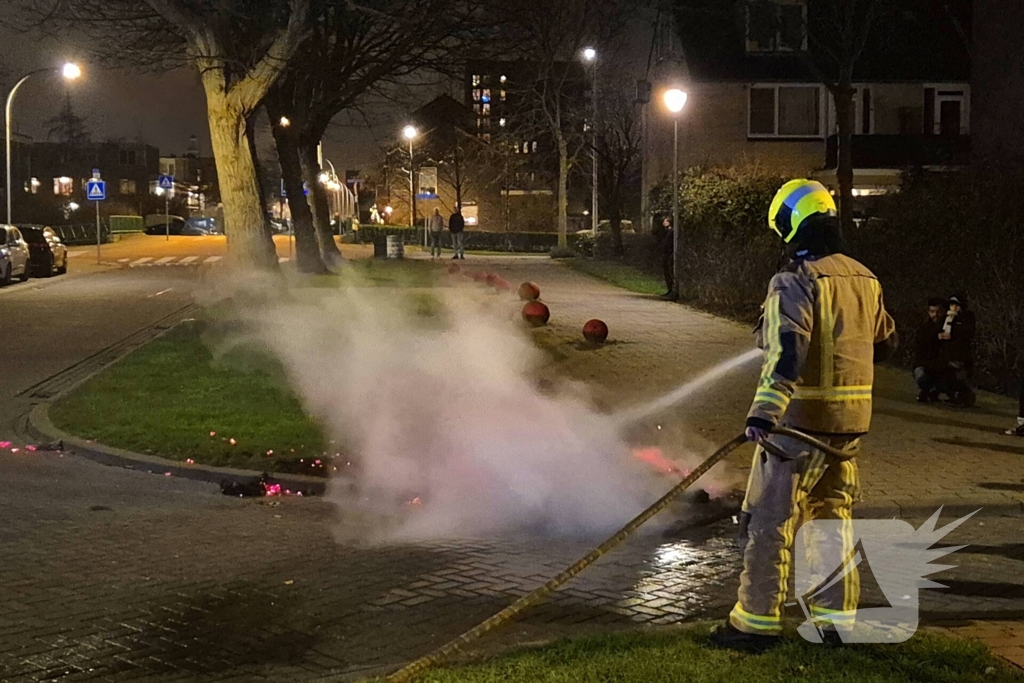 Brandweer blust afvalbrand op straat