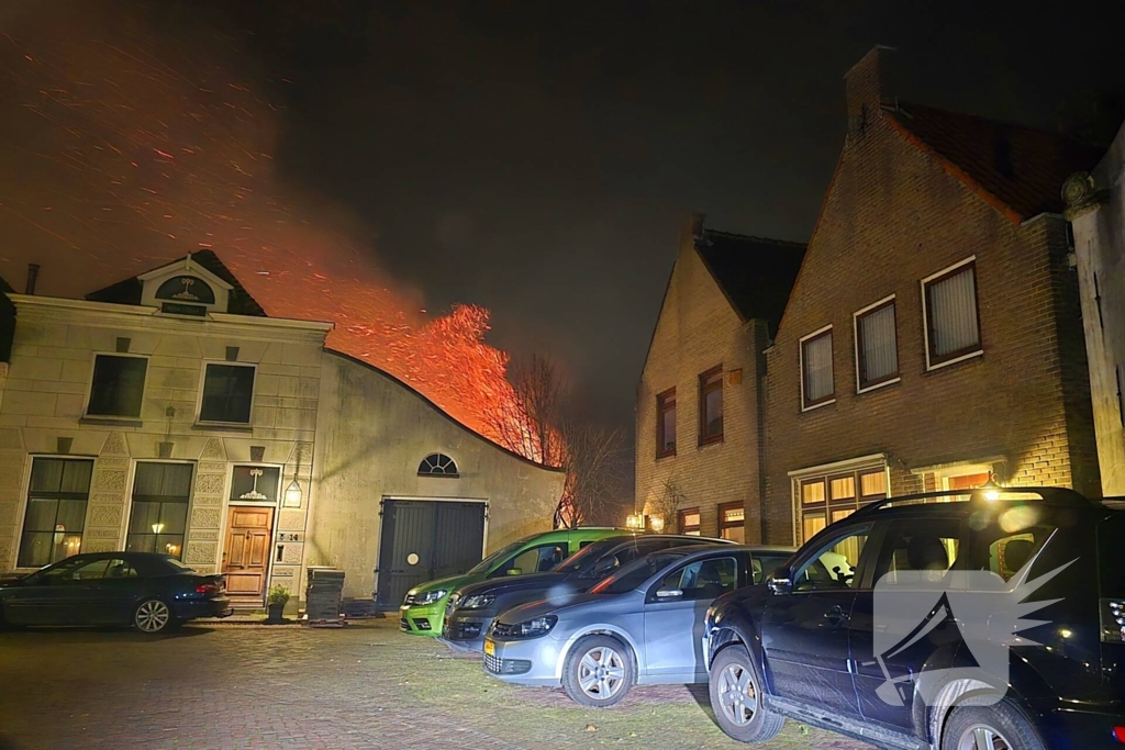 Brandende coniferen haag met tuinslangen geblust