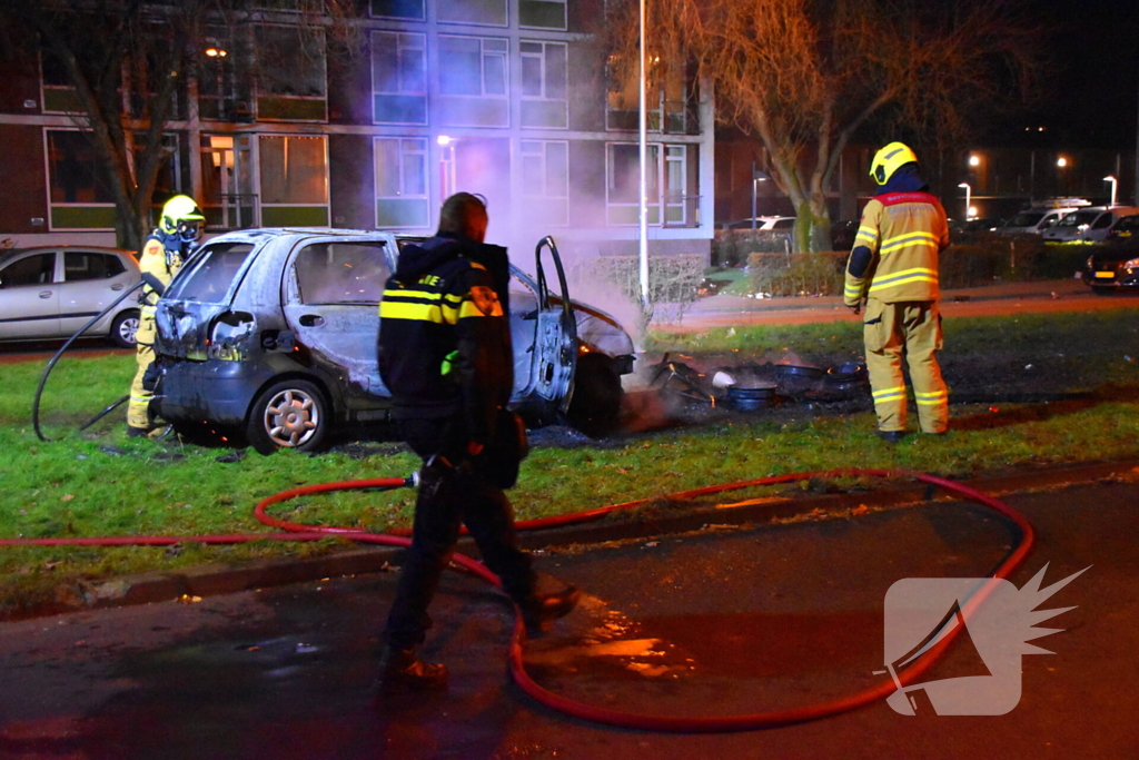 Auto in brand gestoken op grasveld