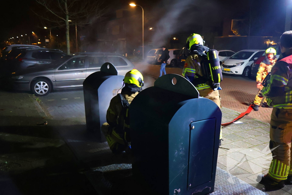 Personen verrichten bluspoging bij containerbrand