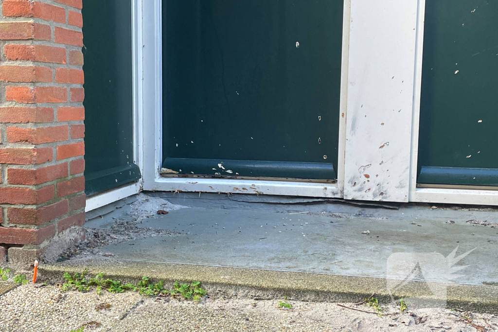 Voordeur van een woning beschadigd door een explosief