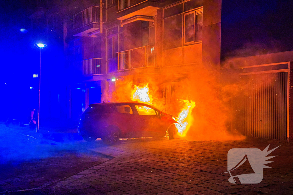 Auto brandt uit tegen gevel van flatgebouw