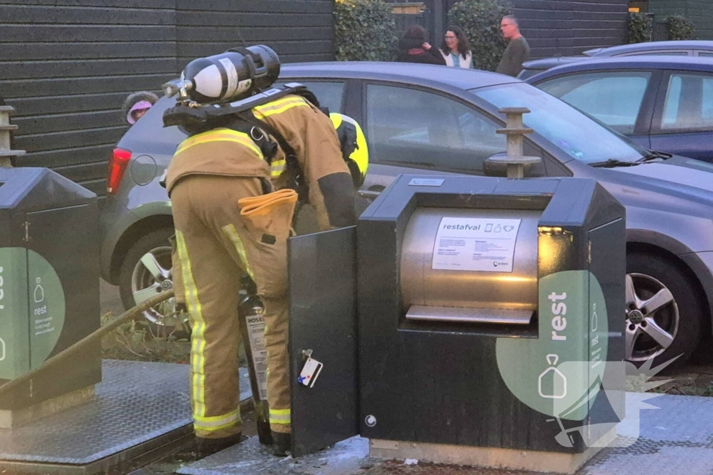 Brandweer dooft brand in ondergrondse vuilcontainer