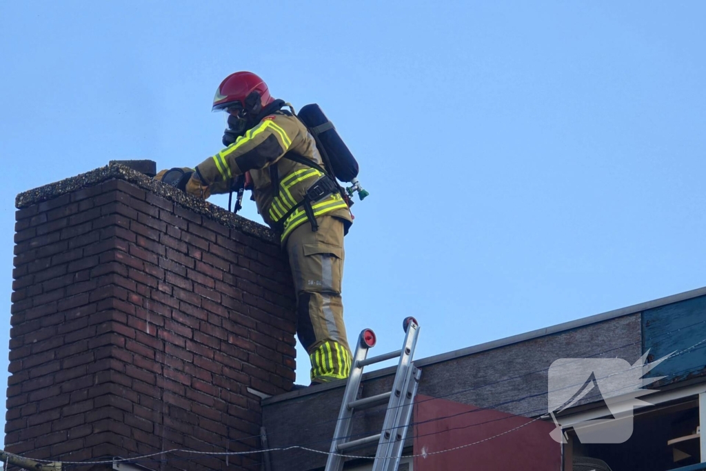 Brandweer veegt schoorsteen na brand