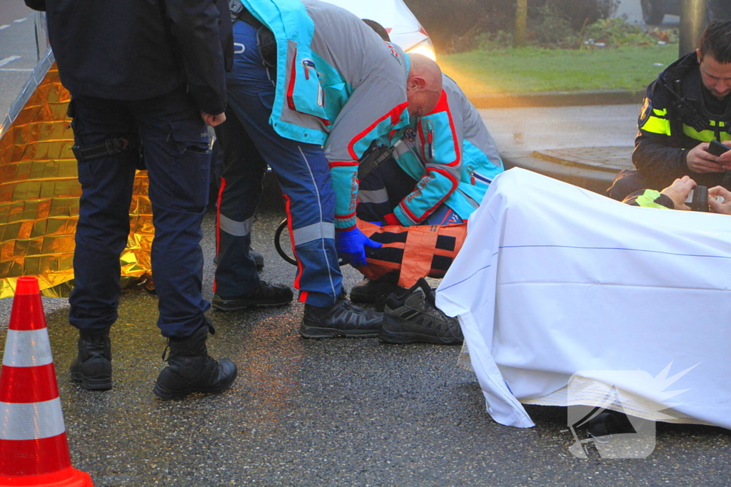 Motorrijder hard onderuit na rem actie fietsende schooljeugd