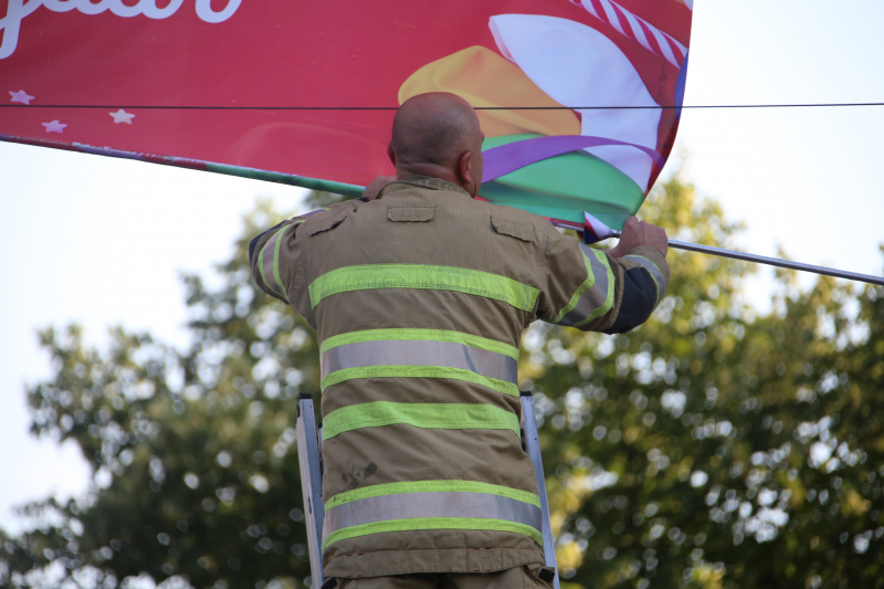 Brandweer zet loshangend reclamedoek vast