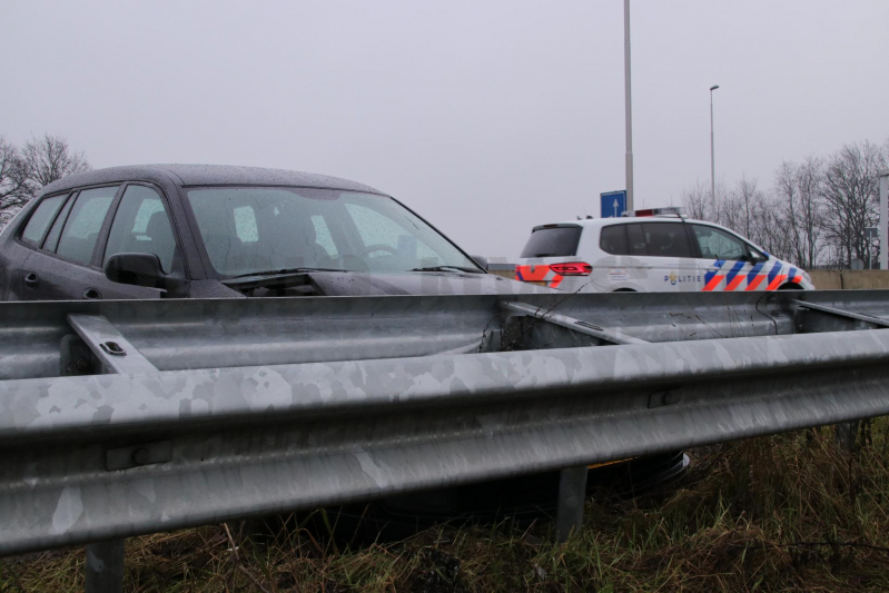 Auto raakt in slip knalt in vangrail