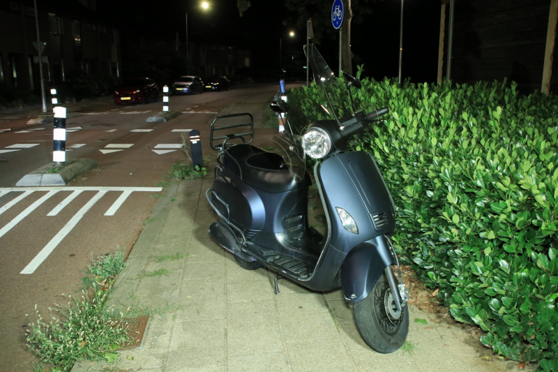 Snorscooter klapt op paal bij oversteekplaats, jonge dame buiten westen