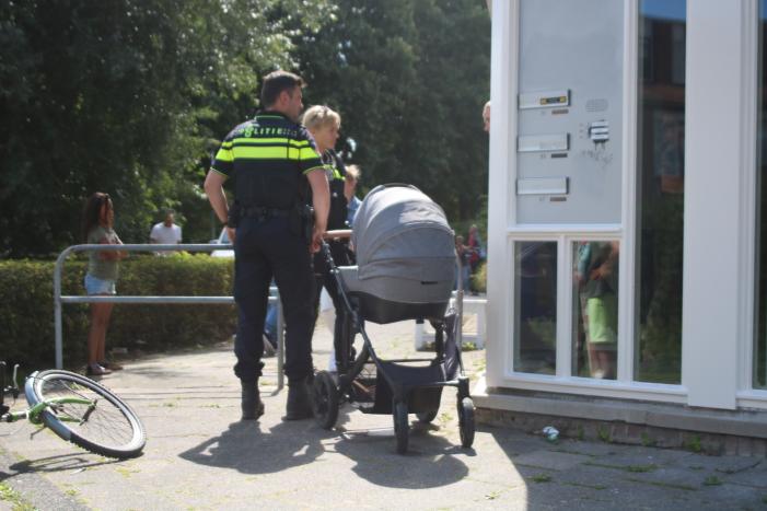 Kinderwagen met baby raakt te water