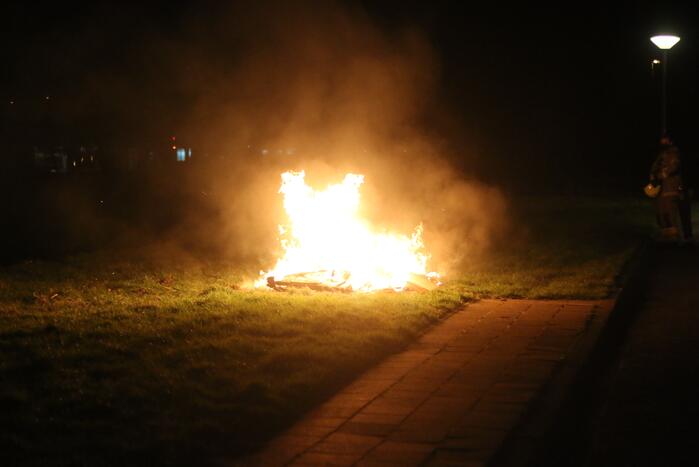 Brandweer blust brandende matras en pallets