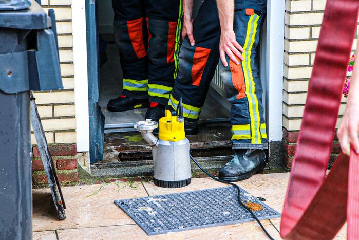 Brandweer helpt met leegpompen van onderwater gelopen woning